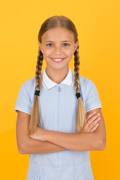 Emotionele intelligentie beschrijft het vermogen om je eigen emoties in de gaten te houden Glimlachend meisje Schattig schoolmeisje gele achtergrond Klein meisje Gelukkige kinderdag Netjes meisje mooi kapsel Positieve emoties