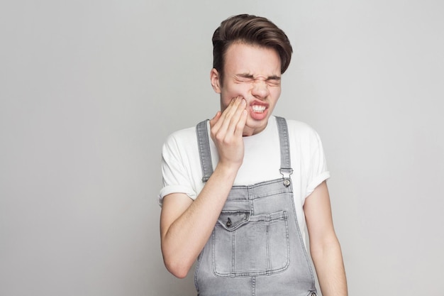 Emotionele jonge man op grijze achtergrond