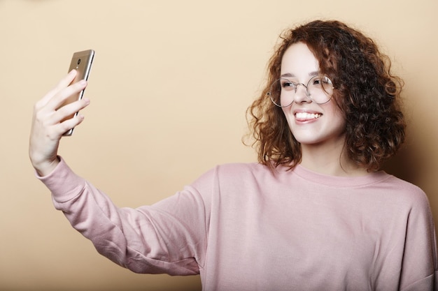 Emotionele levensstijl en mensenconcept Portret van een jonge aantrekkelijke vrouw die selfie-foto maakt op smartphone