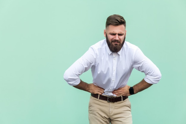 Emotionele man in wit overhemd in de buurt van groene achtergrond