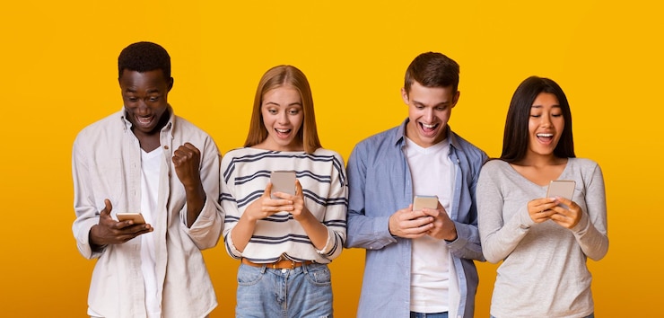 Foto emotionele tienervrienden die in een rij staan en mobiele telefoons gebruiken
