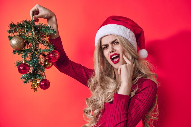 Emotionele vrouw gekleed als kerstboom speelgoed roze achtergrond