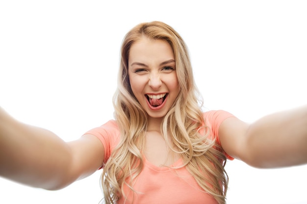 emotions, expressions and people concept - happy smiling young woman taking selfie