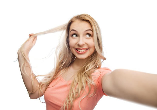 emotions, expressions and people concept - happy smiling young woman or teenage girl taking selfie