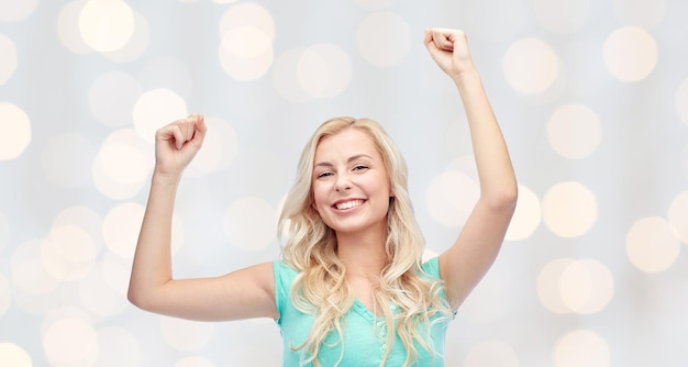 Foto emozioni, espressioni, successo e concetto di persone - felice giovane donna o adolescente che celebra la vittoria sullo sfondo delle luci delle vacanze