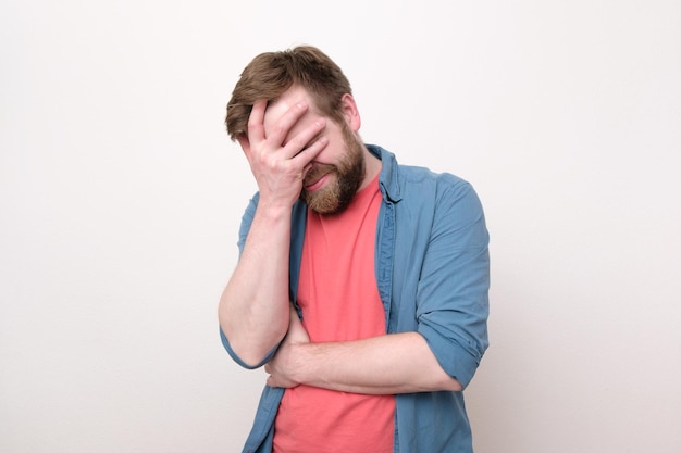 Emotions of fatigue and stress Upset young man covered his face with his hand