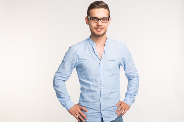 Emotions and people concept - handsome man standing and smiling over the white background.