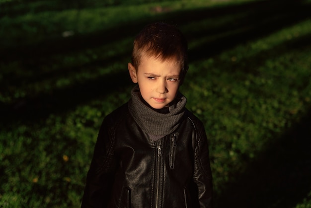 Foto ritratto emotivo di un elegante ragazzo caucasico che indossa una giacca di pelle nera ritratto all'aperto di carino