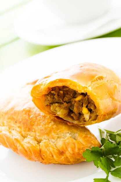 Empanada stuffed with bread on a white plate.