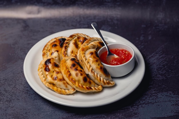 Photo empanadas from argentina regional food with hot sauce