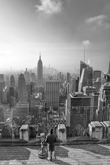 Photo empire state building amidst modern towers in city