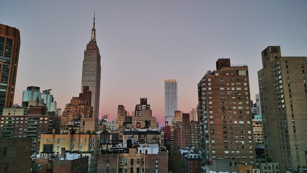 Foto empire state building in città contro un cielo limpido al crepuscolo