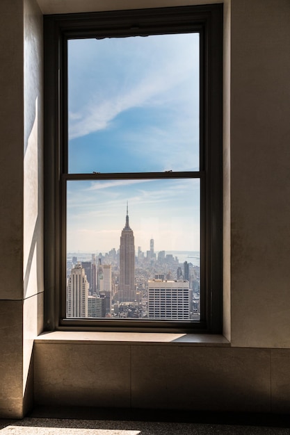 Photo empire state building seen through glass window