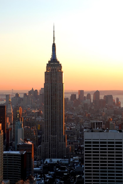Empire State Building te midden van het stadsbeeld tegen de hemel tijdens de zonsondergang