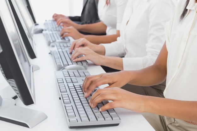 Employee&#039;s typing on their computers