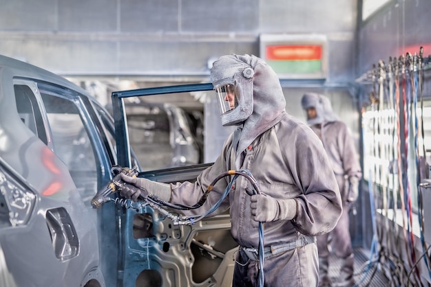 employee of the car body painting shop performs painting.