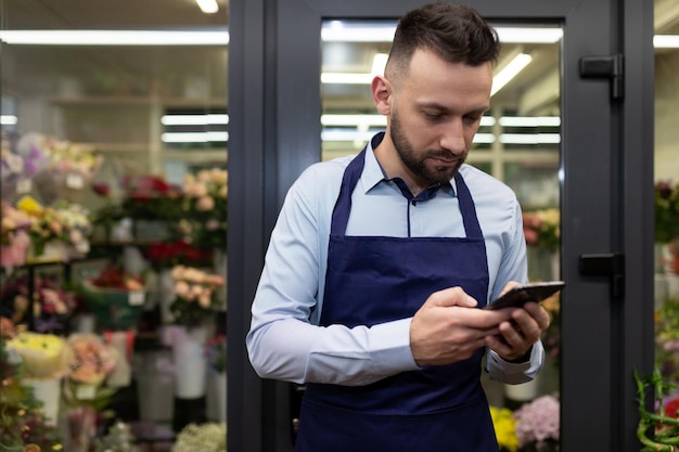 An employee of a floristic boutique takes orders through social networks via the internet