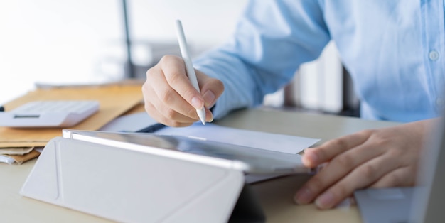 employee hand using stylus pen to pointing on tablet screen to show company profit monthly