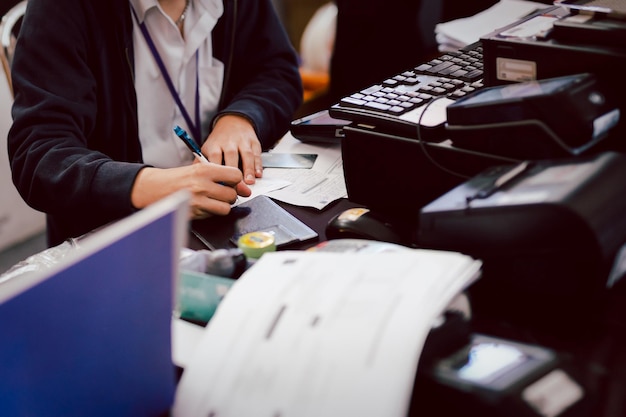 Employee hand writing bank cheque at counter