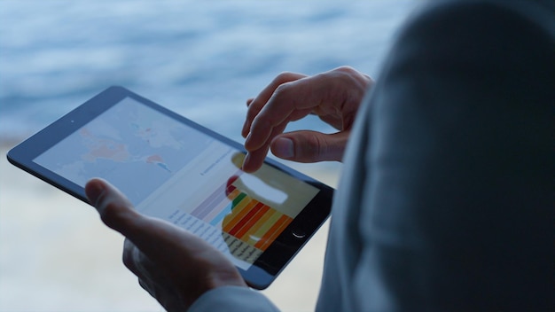 Photo employee hands researching tablet at sea view hotel businessman swipe screen