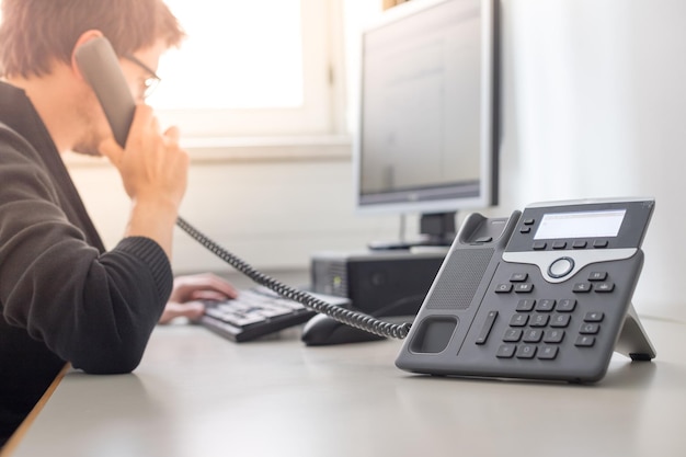 Employee is talking on the phone with customers