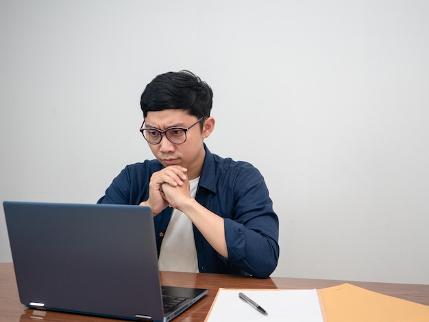 Il lavoratore seduto seduto al lavoro si sente serio con il lavoro al tavolo del posto di lavoro