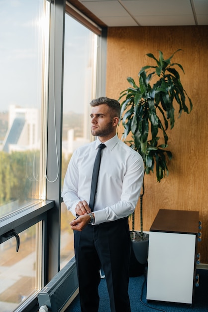 An employee in the office is standing near the window. Finance