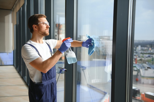 Сотрудник профессиональной службы уборки моет стекла окон здания Уборка витрины для магазинов и предприятий