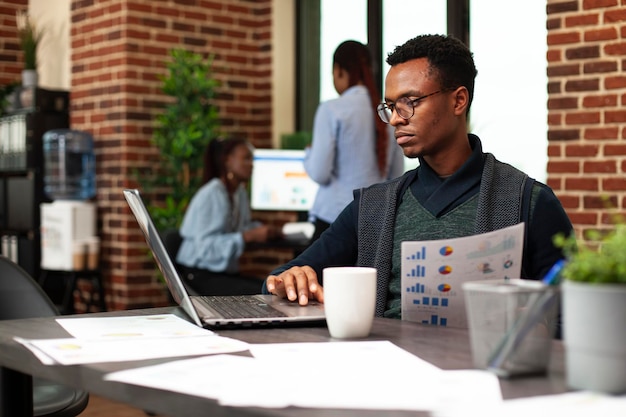 Employee sits with laptop and documents