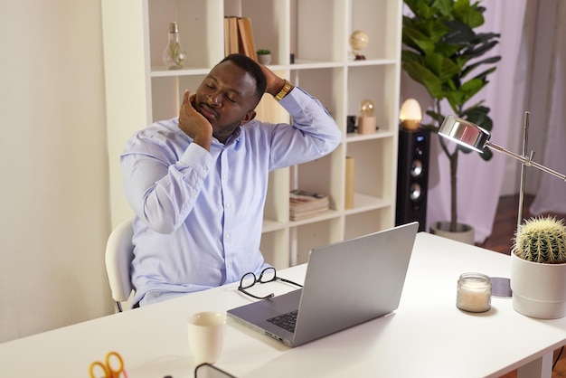 Employee Stretching At Office Desk At Work tired African American office worker