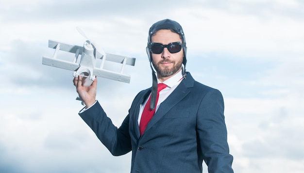 Employee in suit and pilot hat launch plane toy