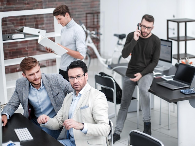 Employee talking on a mobile while sitting on office Deskphoto with copy space