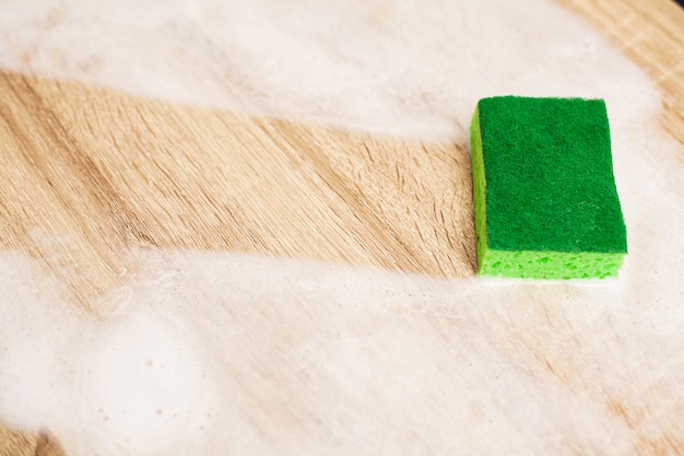 Photo employee using sponge for cleaning wood table