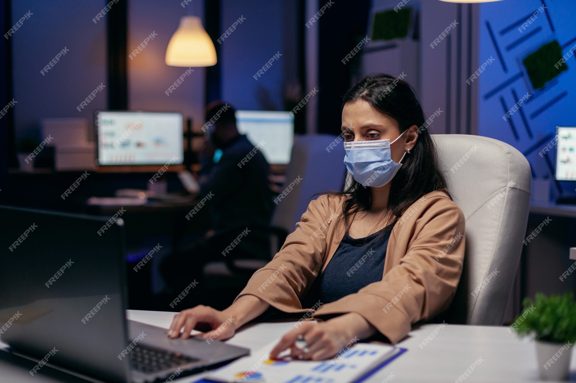 Premium Photo | Employee with protection face mask working late at night in  new normal office. woman following social distancing rules due to  coroanvirus pandemic while working late hours at the office.