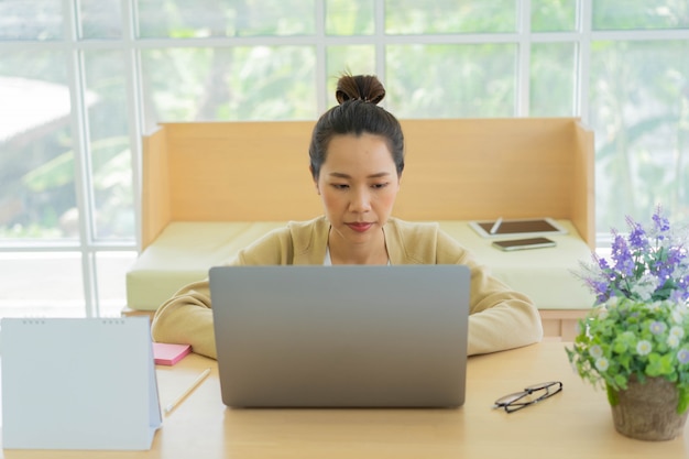 Employee woman using laptop to checking mail , manage task and contact with team at living room