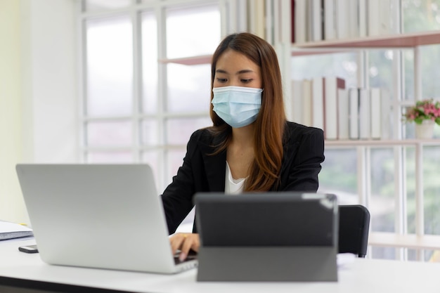 сотрудница, работающая в офисе на работе после пандемии коронавируса