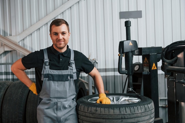 Employee at work man in uniform is in the auto service