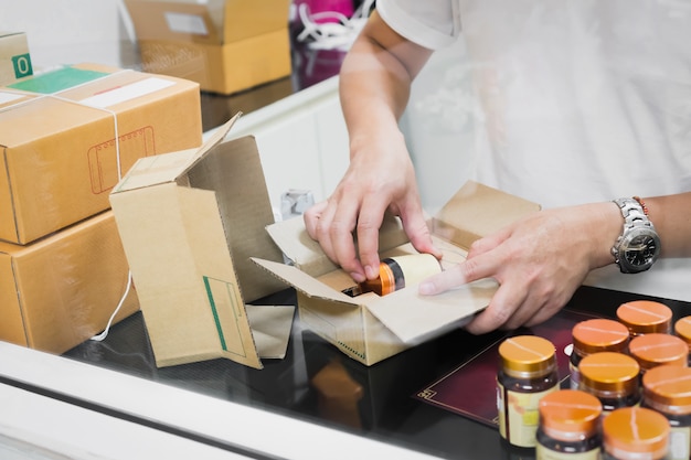 Photo employees are packing a parcel in the send to the customer.