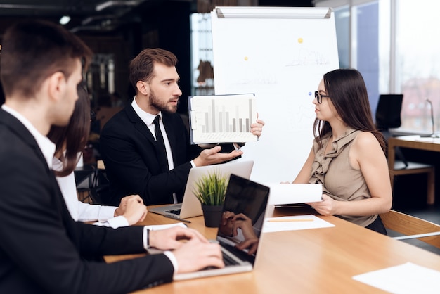 Employees of the company hold a meeting at table.