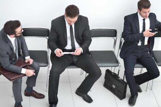 Employees discussing a business document in the hallway of the office