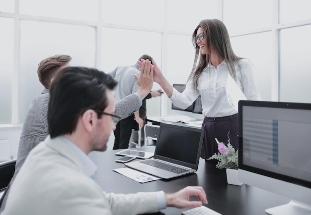 Employees giving high five to the workplace