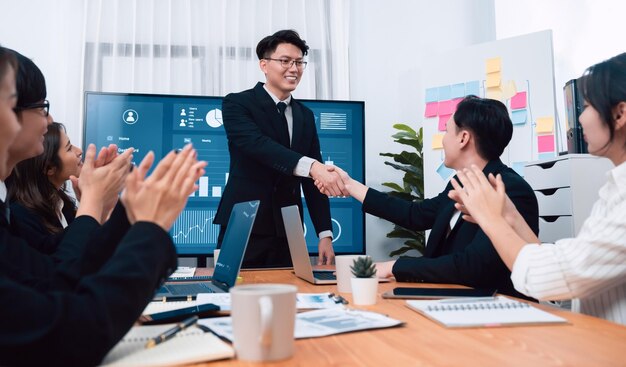 Employees shake hand for symbol of harmony after successful business meeting