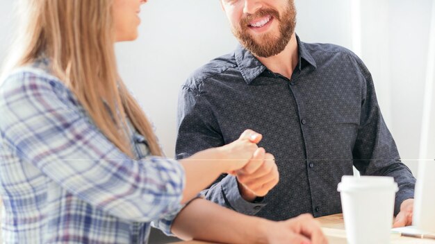 I dipendenti si stringono la mano seduti alla scrivania