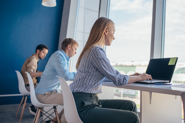 Employees sit at a desk and work