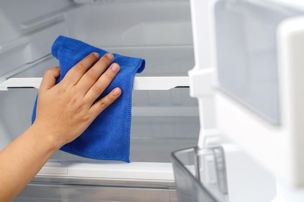 Employees use a cloth to clean the refrigerator