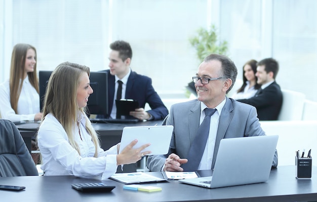 Employees using digital tablet to work with financial data.people and technology