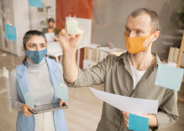 Foto dipendenti che indossano maschere facciali in ufficio