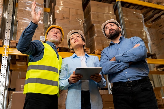 Foto dipendenti con casco che lavorano in magazzino