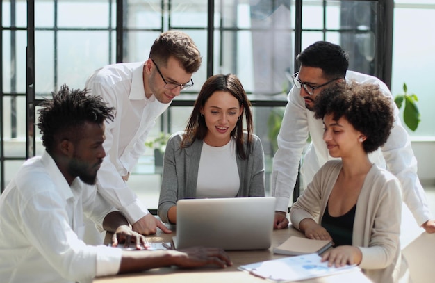 Photo employees working at computer together discussing content