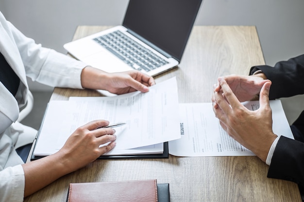 Employer or recruiter holding reading a resume with talking during about his profile of candidate, employer in suit is conducting a job interview, manager resource employment and recruitment concept